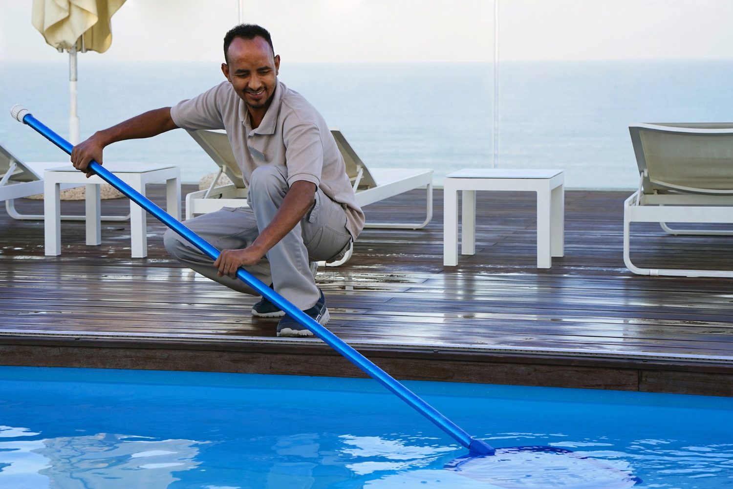 Como deixar a água da piscina cristalina: profissional limpando piscina